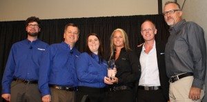 GM Gina Marra accepts the No. 1 dealer trophy from PSB editors (from left) Tom Kaiser, Dave McMahon and Liz Keener.