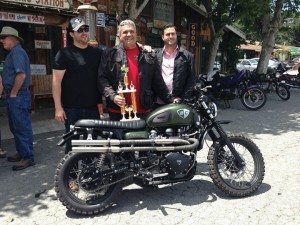 Bryan H. Carroll (center) holding the Quail Ride “Most Unique” trophy with the founders of British Customs, Jason Panther and James Panther.