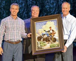 Scott Wine (left) and Bennett Morgan  (right) of Polaris accept a print from the Boy Scouts of America. 