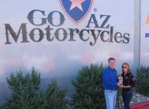 Powersports Business editor in chief Dave McMahon presents the 2014 Power 50 No. 1 dealer award to Gina Marra of Go AZ Motorcycles.