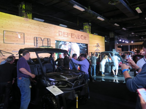Dealers gather around the Can-Am Defender display in the showroom after the global reveal in Nashville, TN.