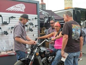 An Indian Motorcycle staffer assists a rider in getting fit for handlebars on the Indian Scout at the Polaris booth on Lazelle Street. Polaris doubled the size of its display from 2014 to 2015.